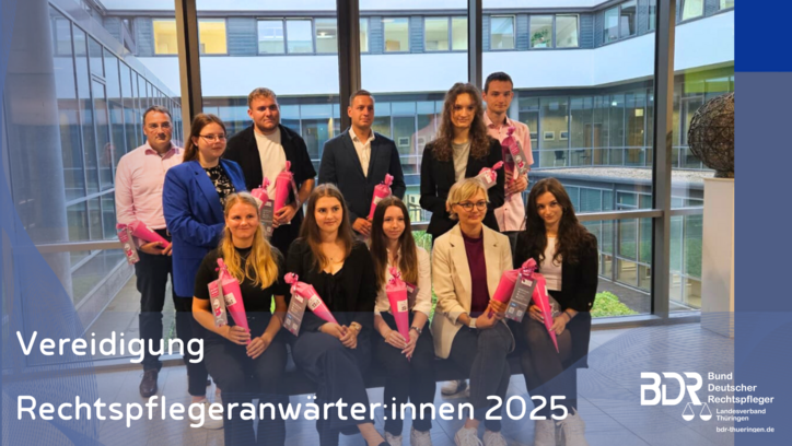 11 junge Anwärter:innen posieren in zwei Reihen für ein Foto und haben pinke Zuckertüten in der Hand.